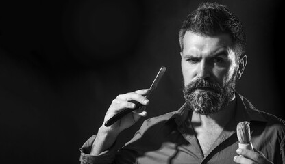 Barbershop service. Brutal bearded man with straight razor and shaving brush. Handsome barber,...