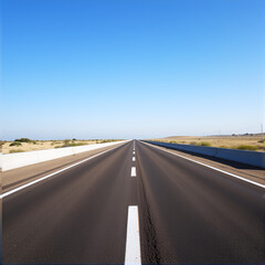 A straight asphalt road featuring white lane markings stretches into the distance under a clear sky, ideal for driving or cycling