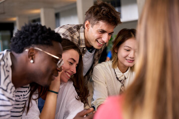 Group of international young language students together meeting looking something sitting in...