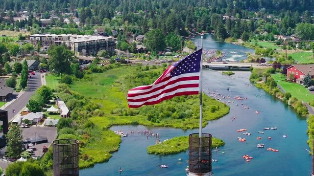 Patriotic Flow: Aerial Drone Shot of the Deschutes River with Rafting and American Flag in Bend, Oregon