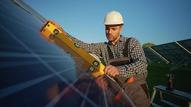 A dedicated technician uses a level tool to ensure the solar panels are correctly aligned for optimal energy production on a bright