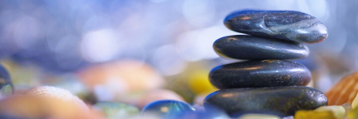 A prominent, stacked rock structure stands tall amidst a blurred, variegated background, embodying harmony, balance, and the serene art of nature.