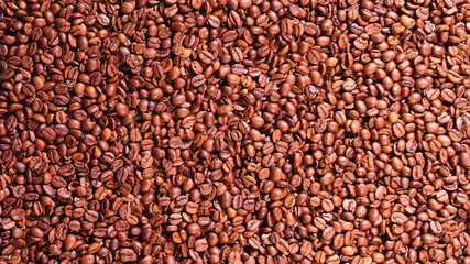 A close-up view of freshly roasted coffee beans, showcasing their rich brown color and texture, perfect for coffee enthusiasts and culinary art lovers.