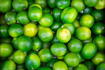 Many lime citrus fruits at a fruit market. Food background. Top view