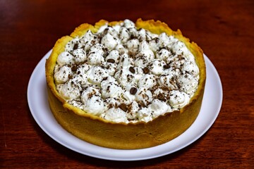 Traditional banoffee cake with banana and caramel sauce filling sprinkled with grated dark chocolate and coffee . English traditional pie