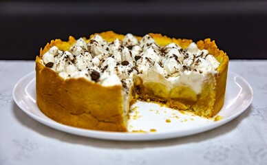 Traditional banoffee cake with banana and caramel sauce filling sprinkled with grated dark chocolate and coffee . English traditional pie