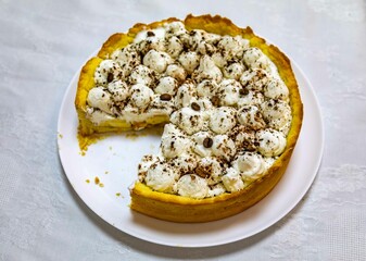 Traditional banoffee cake with banana and caramel sauce filling sprinkled with grated dark chocolate and coffee . English traditional pie