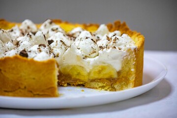 Traditional banoffee cake with banana and caramel sauce filling sprinkled with grated dark chocolate and coffee . English traditional pie