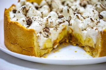 Traditional banoffee cake with banana and caramel sauce filling sprinkled with grated dark chocolate and coffee . English traditional pie