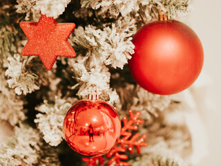 Christmas tree decorations on branches of Christmas tree. Decorations in form of red balls and hexagonal star on decorative Christmas tree. Celebrating New Year. December 31, 2024 - Pula, Croatia