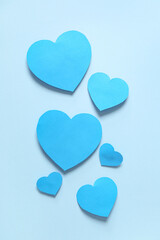 Composition with blue paper hearts on color background. Valentines Day celebration