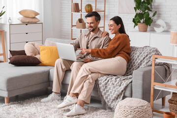 Young couple using laptop at home on autumn day