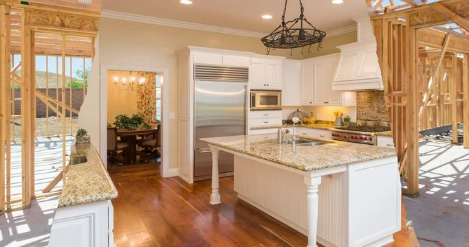 Before and After of Woman Using Painting Roller to Reveal Completed Custom Kitchen Under Wood Construction Framing.