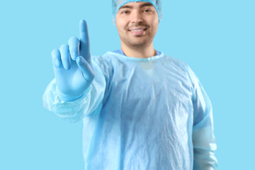 Naklejka premium Male doctor using virtual screen on blue background