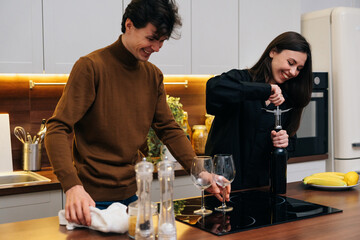 Young couple enjoying wine tasting together in a cozy kitchen at home