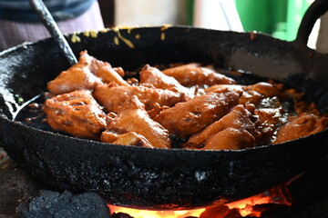 Bread pakora is being fried in hot oil. It is made by stuffing the bread with potatoes and dipping it in the batter of chickpea flour and then frying it. popular snack of India. Indian street food. 
