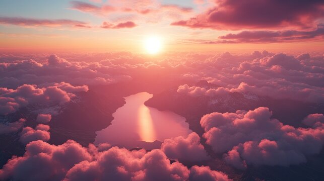 Aerial sunset over pink clouds, mountain lake, and snowy peaks.
