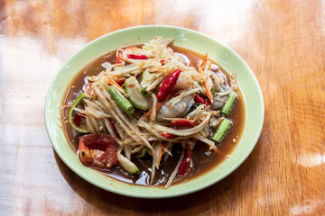 Green papaya salad in a plate on a table.
