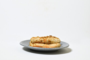 Traditional Indonesian Food, known as otak-otak ikan. Made from fish and served on the grey or gray plate. Wide view. Isolated on white background. Copy space, empty space, free space, negative space.
