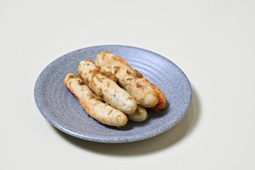 Traditional Indonesian Food, known as otak-otak ikan. Made from fish and served on the grey or gray plate. Close up view. Isolated on white background.