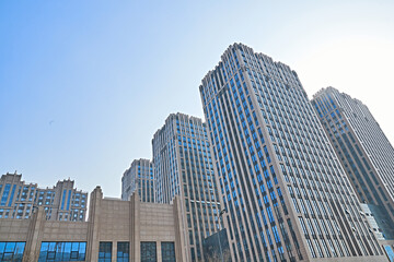 Fototapeta premium Looking up at modern office buildings and local landscape