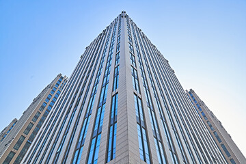 Fototapeta premium Looking up at modern office buildings and local landscape