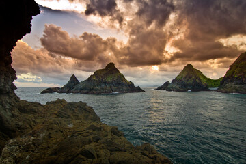 view of the sea at dusk with several sharp cliffs in the middle