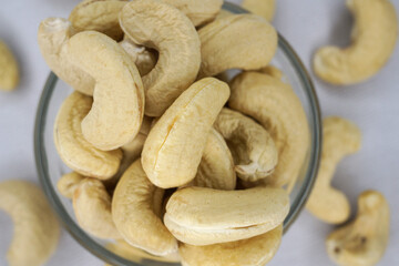 Raw cashew nuts in bowl or burlap sack on white background. Selective focus. Healthy vegetarian snack, Anacardium occidentale