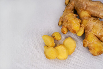 Fresh ginger rhizome root with sliced piece isolated on white background. Herb medical concept. Ginger contains antioxidants. These molecules help manage free radicals and help with blood pressure