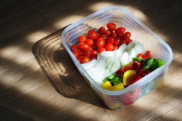 Top view of vegetables in bowl with natural light on dark background