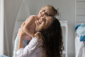 Adoption day. Portrait happy tender millennial foster mother cuddle hug hold in embraces with...