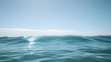 Fototapeta premium A serene ocean view under a clear sky, showcasing gentle waves and sunlight reflections.