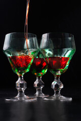 Elegant green glasses filled with vibrant red liqueur, creating a striking contrast and a sophisticated presentation for a refined beverage experience.