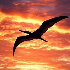 A silhouette of a pterosaur flying against a vibrant sunset backdrop.