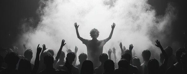 Silhouettes of crowds people holding hands up. wide photo peoples having fun during amazing music performance