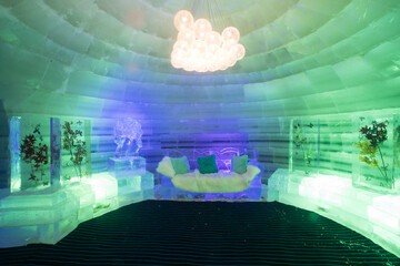 The dreamy ice room in the ice castle is illuminated by colorful lights and shadows