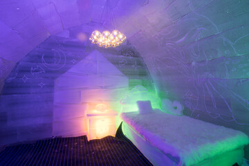 The dreamy ice room in the ice castle is illuminated by colorful lights and shadows