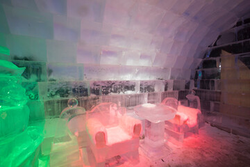 The dreamy ice room in the ice castle is illuminated by colorful lights and shadows