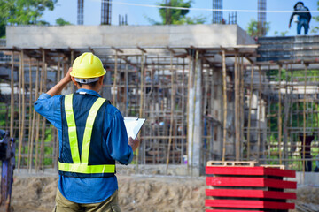 engineer inspector checking work with construction drawing at building site	