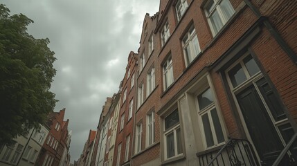 Obraz premium Urban Street with Brick Buildings Under Cloudy Sky