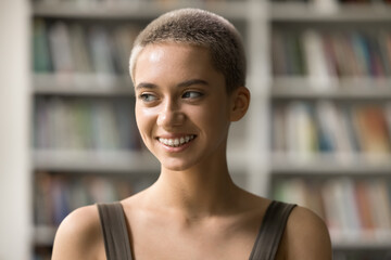 Self confidence. Head shot portrait smiling attractive female teenager student with stylish short hairdo on blond hair in hipster style modern bracket system on teeth posing indoors look aside think
