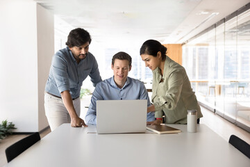 Multiethnic professional team talking at laptop computer, watching online project presentation...