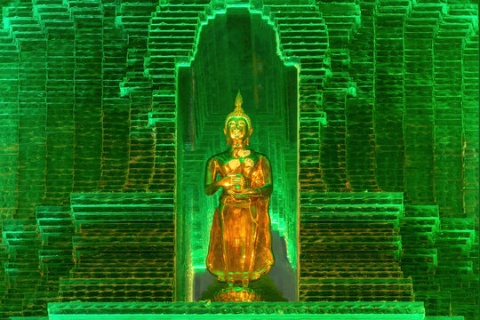 Closeup of golden Buddha statue in emeral-green glass pagoda. At Buddist temple Wat Paknam Phasi Charoen, Bangkok, Thailand. 
