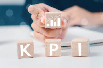 KPI, Key Performance Indicator. Businessman holds cube with KPI icon; business goals, performance results and indicators . For business planning and measure success, target achievement. Copy space.