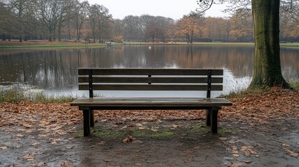 Autumn park bench by lake, tranquil scene.