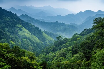 Lush Green Mountains Under a Cloudy Sky With Layers of Blue-Hued Peaks in the Distance