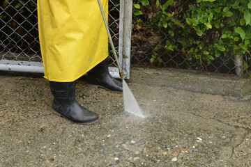 Outdoor pressure washing with high pressure water jet. The cleaning man washes the concrete....