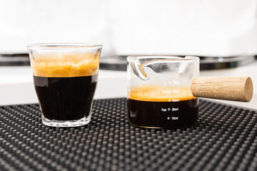 Two glass cups for hot drink coffee menu prepared in espresso coffee machine at the cafe.Differrent black coffee for barista preraring differrence menu.Awakening drink.
