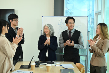 Group of professional businesspeople applauding after a successful presentation in modern office