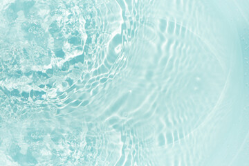 Obraz premium Blue water with ripples on the surface. Defocus blurred transparent blue colored clear calm water surface texture with splashes and bubbles. Water waves with shining pattern texture background.